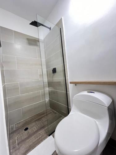 a bathroom with a toilet and a glass shower at HOTEL 9.5 SAN FERNANDO in Cali