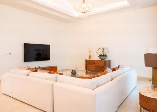 a white living room with a white couch and a tv at Kempinski Hotel & Residences Palm Jumeirah in Dubai