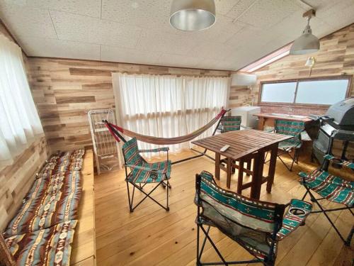 a dining room with a wooden table and chairs at 『沙羅居 レトロ&グランピング』名古屋駅徒歩10分の異空間 広々100 ㎡ 貸切古民家 最大11名様 in Chiharachō