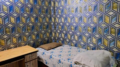 a bedroom with a bed and a blue and gold wall at Narmada Guest House in Indore