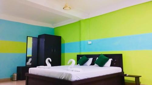 two swans sitting on a bed in a room at The PugMark Wildlife Resort in Jyoti Gaon