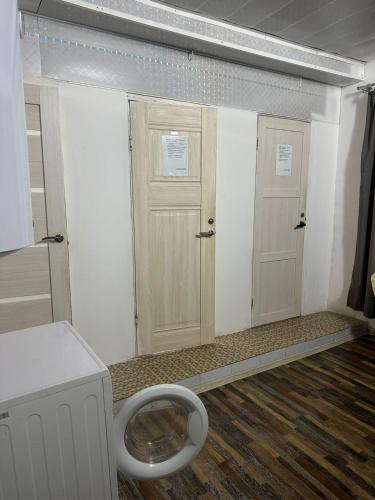 un bagno con due porte e servizi igienici di ДОМ Hostel a Almaty