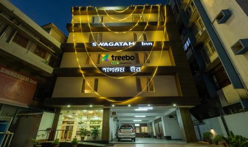 a building with a car parked in front of it at Treebo Trend Swagatam Inn in Guwahati