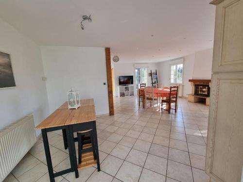 eine Küche und ein Wohnzimmer mit einem Tisch und Stühlen in der Unterkunft Maison chaleureuse en Normandie in Habloville