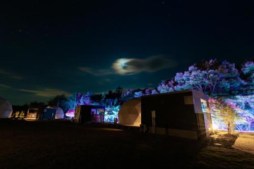 a group of tents in a field at night at レドンド秋吉台 in Ōta