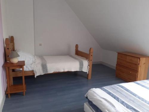 - une petite chambre avec 2 lits et une table de nuit dans l'établissement Maison chaleureuse en Normandie, à Habloville