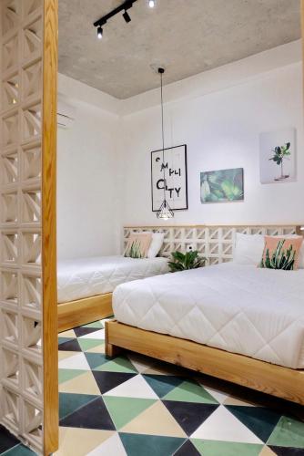 two beds in a bedroom with a checkered floor at URI HOUSE, 1-2 BR tourism apt, 5' walk Dragon Bridge in Danang