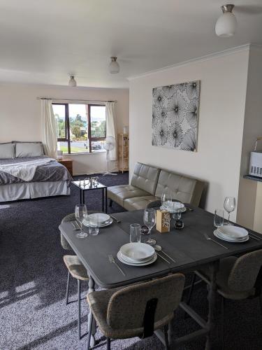 ein Wohnzimmer mit einem Tisch und einem Bett in der Unterkunft Number 57 in Auckland