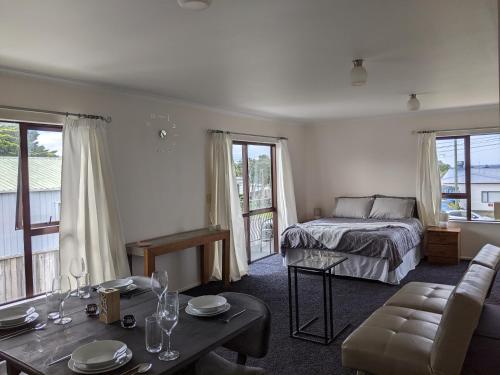ein Schlafzimmer mit einem Bett, einem Sofa und einem Tisch in der Unterkunft Number 57 in Auckland