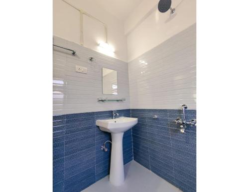 een badkamer met een wastafel en blauwe tegels bij Hotel Dawa Tawang, Arunachal Pradesh in Tawang