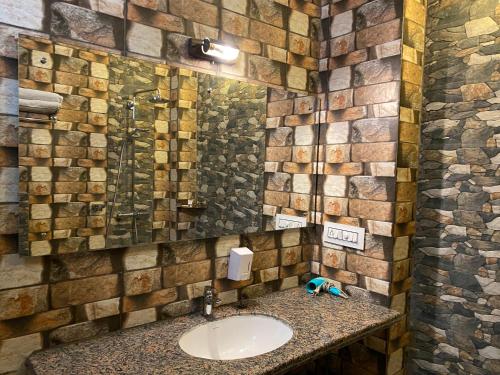 een badkamer met een wastafel en een stenen muur bij Shahi Guest House in Jodhpur