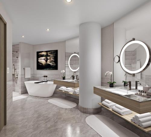 La salle de bains est pourvue de 2 lavabos, d'une baignoire et d'un miroir. dans l'établissement InterContinental Hotels Bellevue at the Avenue, an IHG Hotel, à Bellevue