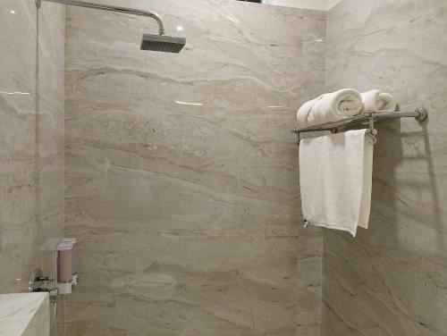 a bathroom with a shower with white towels at BK Castles Hotel in Jabalpur