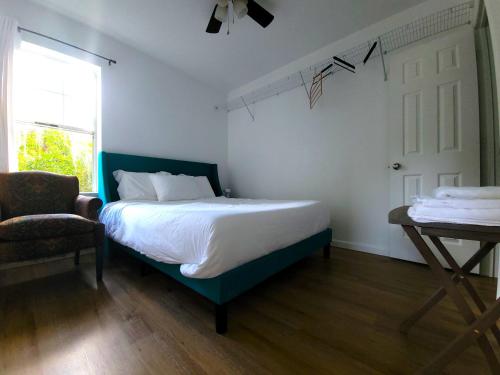 1 dormitorio con 1 cama, 1 silla y 1 ventana en One room in a renovated duplex house near FSU, en Tallahassee