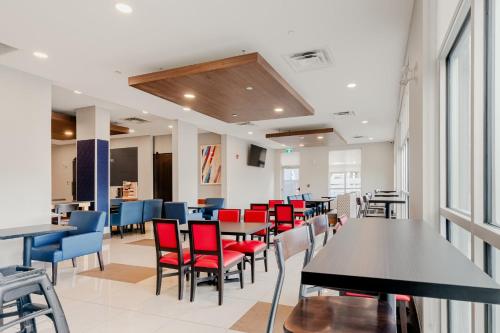 uma sala de jantar com mesas e cadeiras vermelhas em Holiday Inn Express Hotel & Suites-Edmonton South, an IHG Hotel em Edmonton