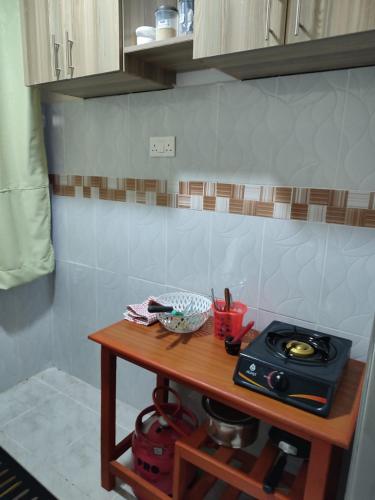 a small table in a kitchen with a stove at Elim apartment in Kitengela 