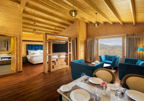 ein Wohnzimmer mit einem Bett, einem Tisch und Stühlen in der Unterkunft jüSTa Cliffend Resort & Spa, Mashobra in Kīar