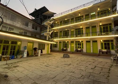a large building with a courtyard in front of it at Trippy Turtle Hostel in Manāli