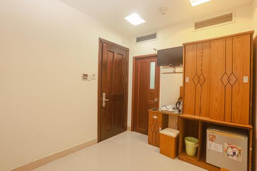 Cette chambre dispose d'une cuisine avec des placards en bois. dans l'établissement Song Anh 3 Hotel, à Hô-Chi-Minh-Ville
