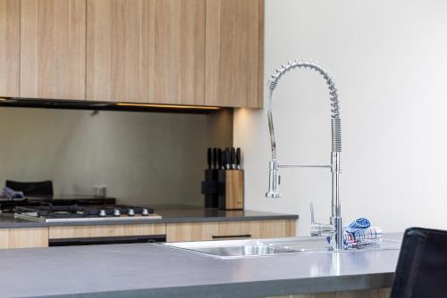 uma cozinha com um lavatório e uma torneira em Stockyards 3 - Jindabyne Luxury Townhouse em Jindabyne