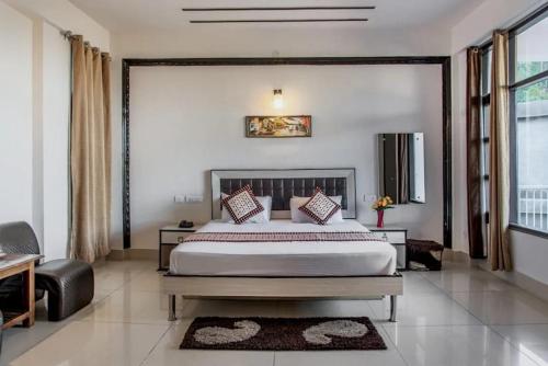 een slaapkamer met een groot bed en een groot raam bij The Terrace Retreat by StayVues in Kasauli