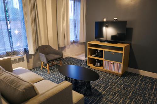 Hotel Garrett في سان فرانسيسكو: غرفة معيشة مع أريكة وتلفزيون