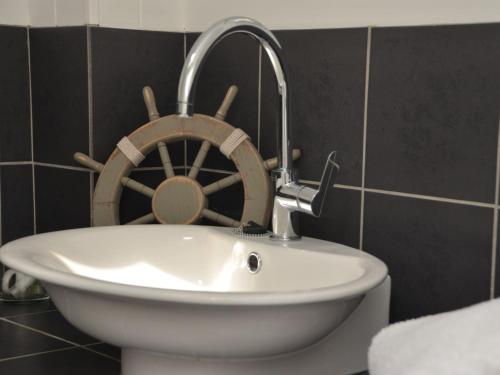 a bathroom with a sink and a wooden boat on the wall at 3 Bed in South Cerney HIC06 in South Cerney