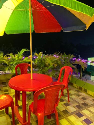 - une table avec des chaises et un parasol sur la terrasse dans l'établissement SAND CASTLE, à Konârak