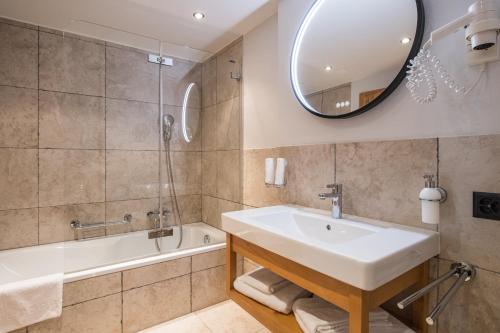 La salle de bains est pourvue d'un lavabo, d'une baignoire et d'un miroir. dans l'établissement Angelina, à Zermatt