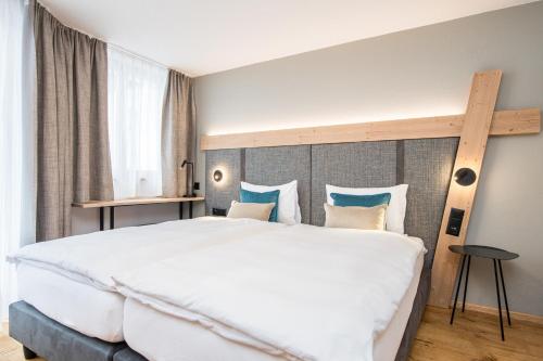 1 dormitorio con 1 cama blanca grande y cabecero de madera en Angelina, en Zermatt