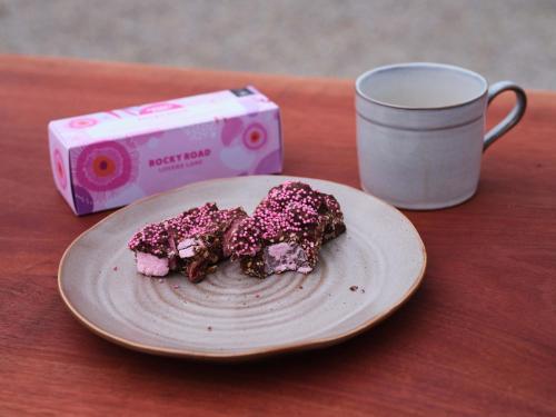 two donuts on a plate next to a cup of coffee at Shawwood Estate in Mudgee