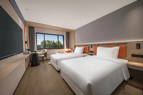 a hotel room with two beds and a tv at Holiday Inn Express Beijing Downtown by IHG in Beijing