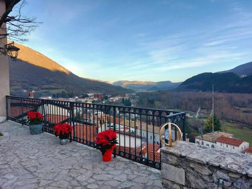 a balcony with red flowers on a fence at Affittacamere Ellera Verde in Villetta Barrea