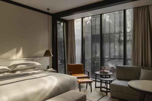 a hotel room with a bed and a large window at Capella Sydney in Sydney