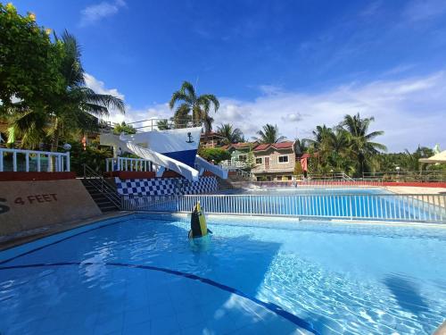 a swimming pool with a boat in the water at JSJS Mountain Resort powered by Cocotel in Talaga