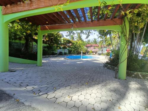 une pergola verte avec une piscine en arrière-plan dans l'établissement JSJS Mountain Resort powered by Cocotel, 