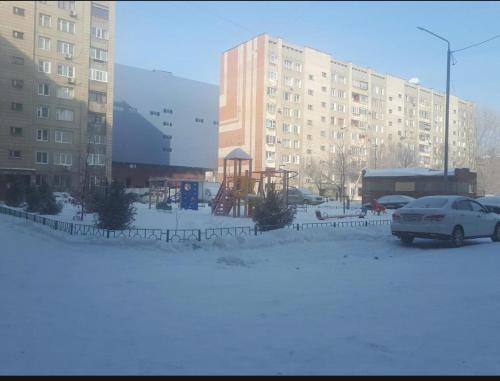 een parkeerplaats met een auto voor een gebouw bij Пермитина 1 комнатная в доль реки Иртыш in Öskemen