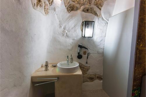 baño con lavabo en una pared de piedra en Tenuta Bouganville With Garden And Pool - Happy Rentals, en Carpignano Salentino