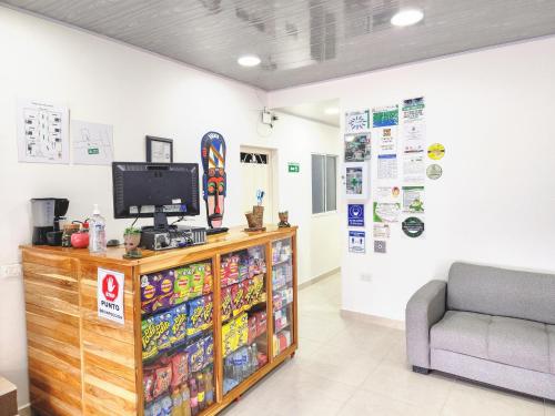 a waiting room with a tv and a couch at HOTEL EL EMPERADOR in Doradal