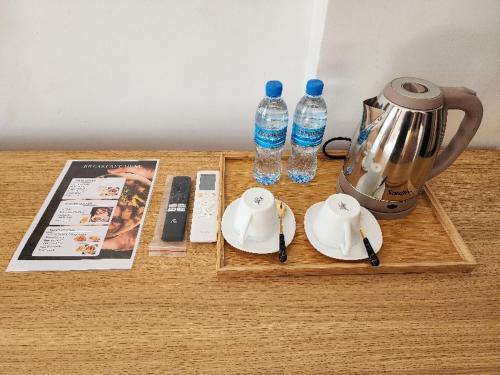 un tavolo con caffettiera, piatti e bottiglie d'acqua di PALM VILLAGE BUSINESS HOTEL APT a Dar es Salaam