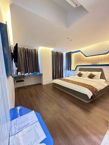 a hotel room with a bed and a table with a table at Golden Palace Hotel in Batu Merah