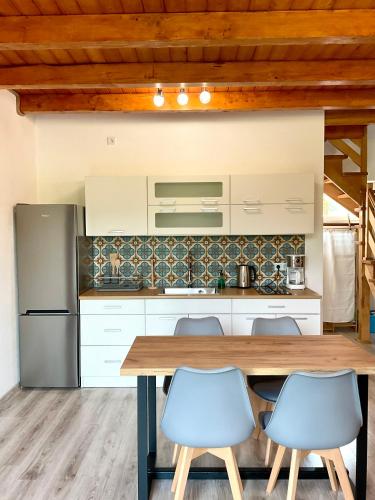 a kitchen with a wooden table and blue chairs at Domki Oaza Ciszy in Polańczyk
