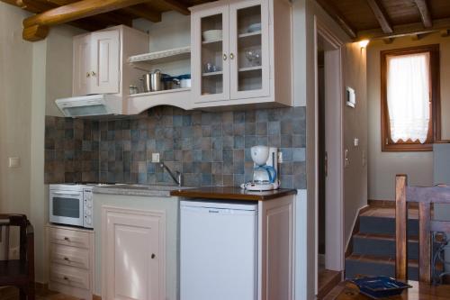a kitchen with white cabinets and a counter top at Stolios in Skopelos Town