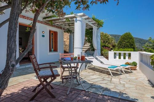 a patio with a table and chairs and a pergola at Stolios in Skopelos Town