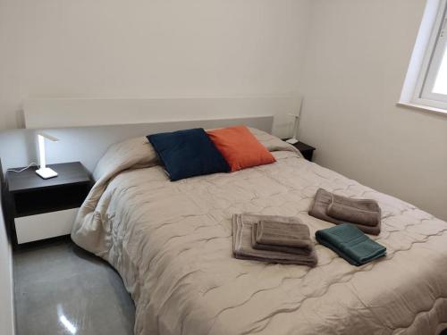 una camera da letto con un letto e asciugamani di Sorriso Flat n.9 - Entire Unit a San Pawl il-Baħar