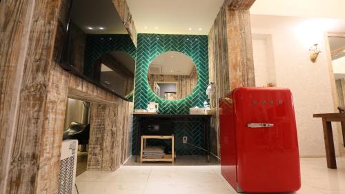 a red refrigerator in a room with a mirror at February Hotel SeongSeo in Daegu