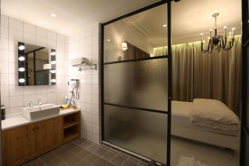 y baño con ducha y lavamanos. en February Hotel SeongSeo en Daegu