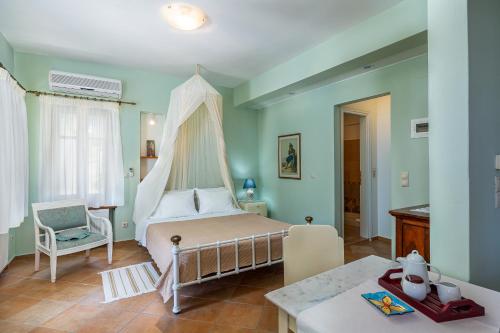 a bedroom with a canopy bed and a chair at Stolios in Skopelos Town