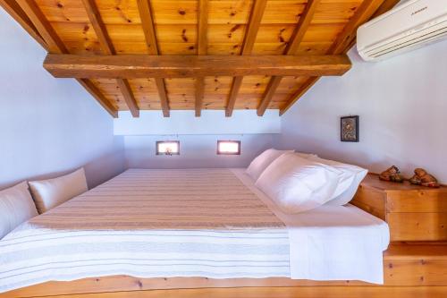 a bedroom with a bed with a wooden ceiling at Stolios in Skopelos Town