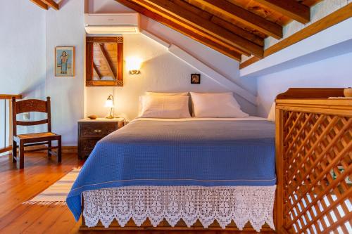 a bedroom with a bed with a blue comforter at Stolios in Skopelos Town